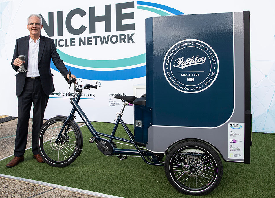 Adrian Williams holding the trophy and standing alongside the ALECs e-cargo trike.