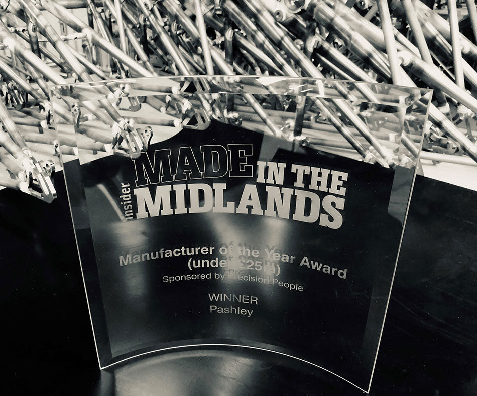 Glass trophy for Made in the Midlands manufacturer of the year award, alongside bicycle frames.