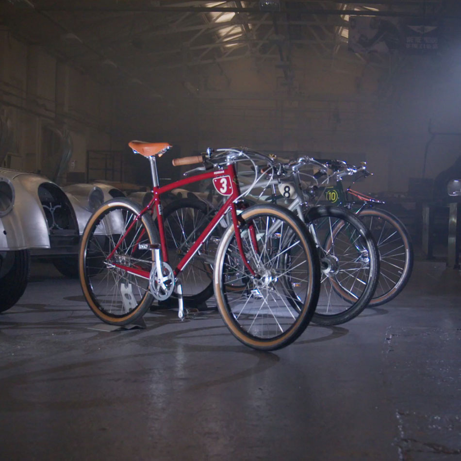 Red, silver and green Pashley-morgan classic race bikes standing in the Morgan motor factory.