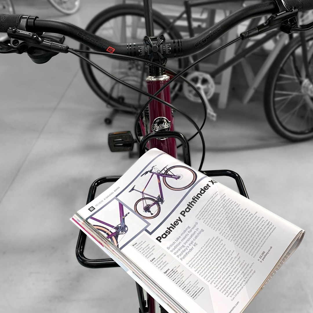 Open magazine showing a Pashley ebike balanced on the front rack of a bike