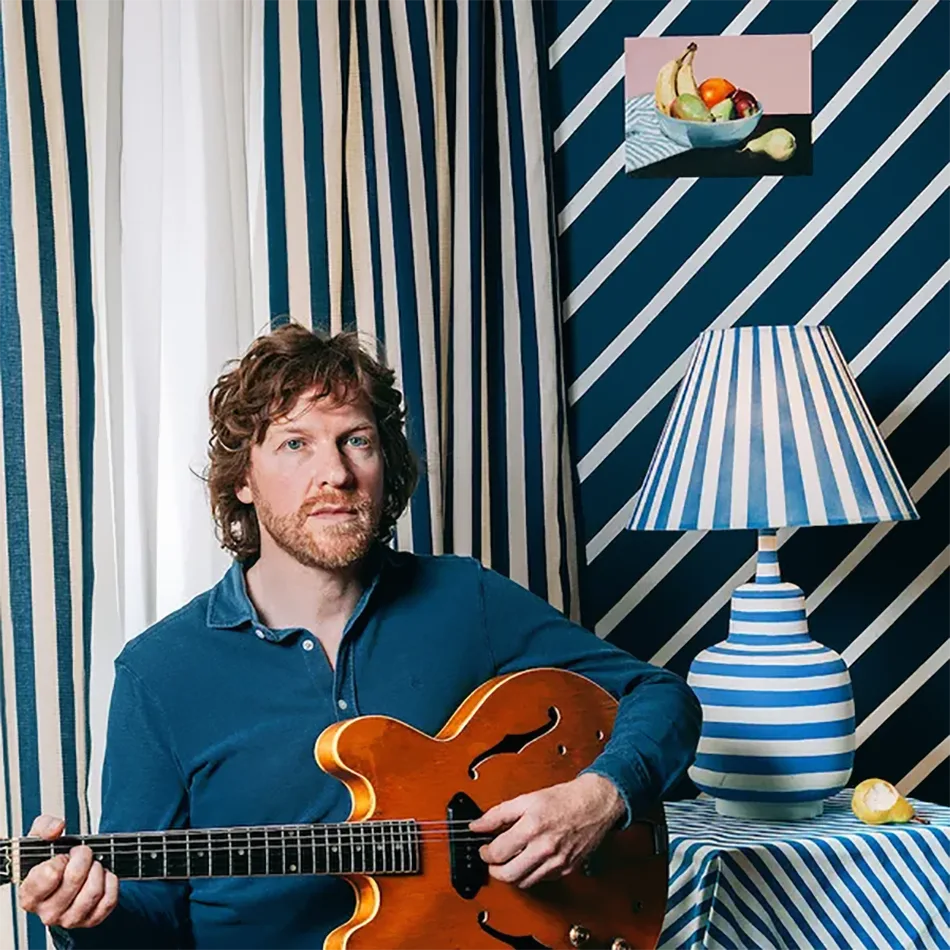 Canadian Singer, Doug Paisley, sat with his guitar in a room full of stripy decorations!