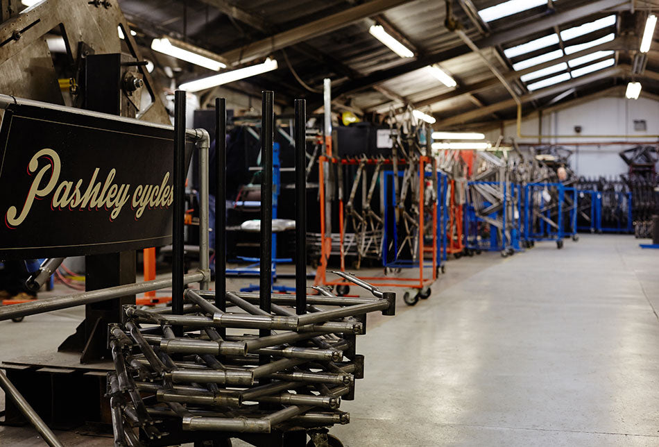 Inside the Pashley Cycles factory with bare bicycles frames racked and ready to be painted.