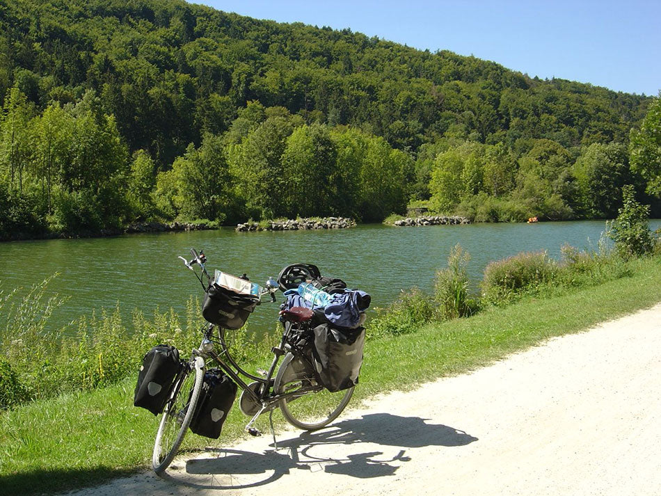 Pashley Princess classic ladies bicycle on a cycle path next to a river, fully laden with panniers for long distance touring