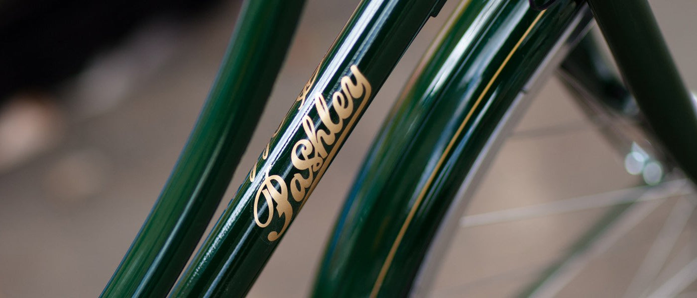 The Pashley logo in gold on the down-tube of a Pashley Princess in Regency Green.