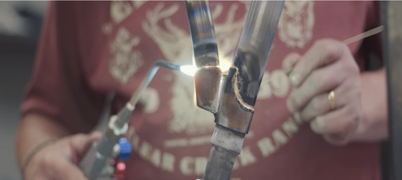 Close-up of a Pashley craftsman brazing a classic bicycle frame.