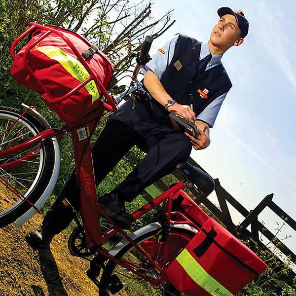 Postman standing with Royal Mail Star bicycle laden with post bag and panniers