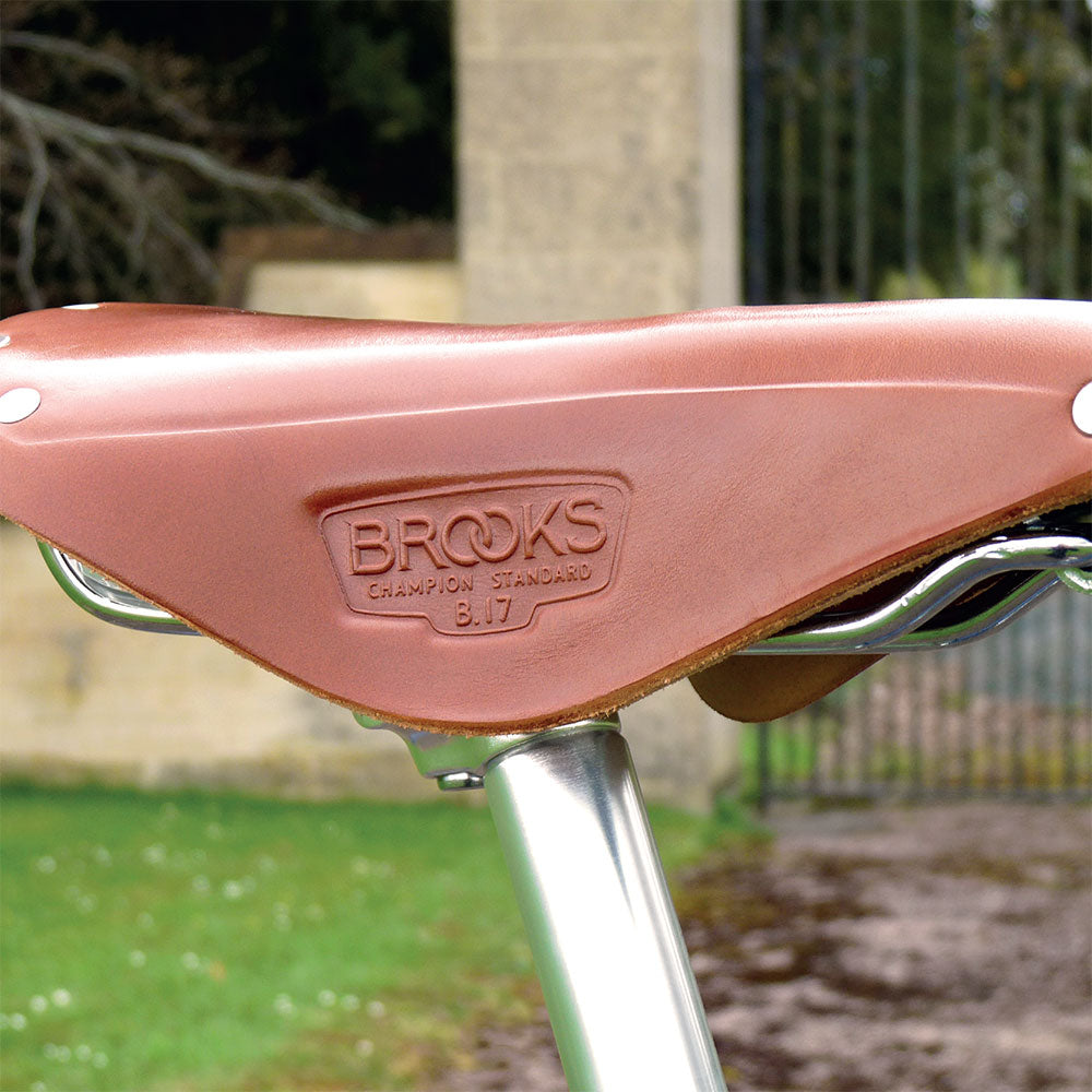 A close-up of a tan leather Brooks B.17 Champion Standard bicycle saddle.