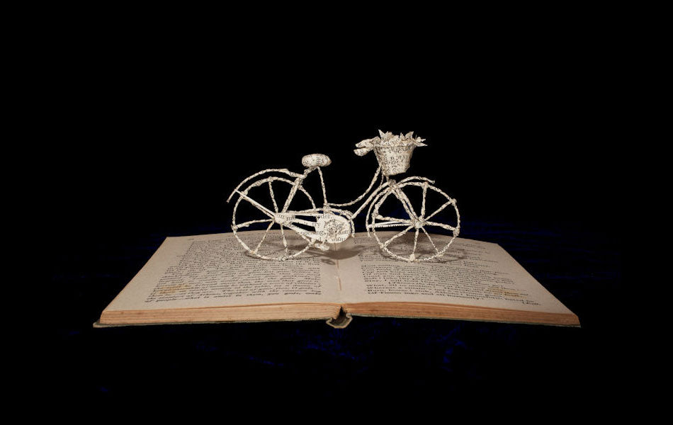 A sculpture of a Pashley Princess bicycle made from the pages of an antique book.
