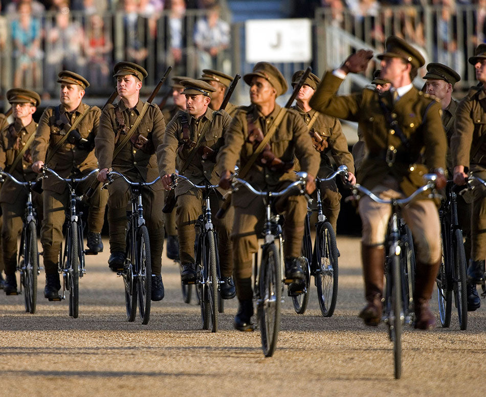 Large peloton of riders from the royal Household Cavalry in uniform riding Pashley roadster bicycles on horse guards parade