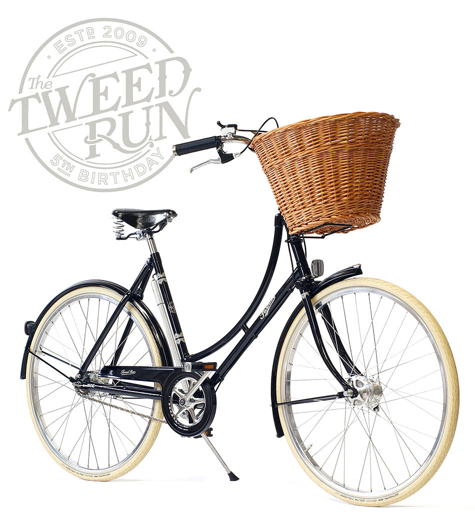 A black special edition 2013 Tweed Ride bike made by Pashley with lace detailing and a large wicker basket.