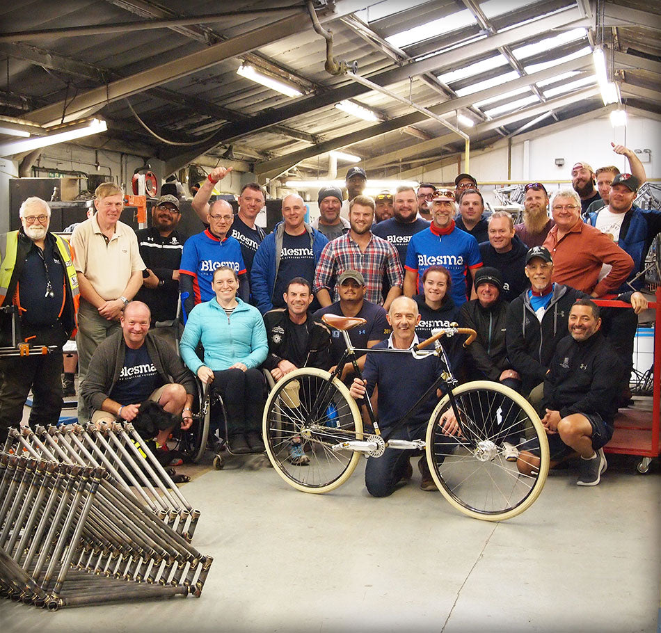 A group photo of ex-service men and women on the factory floor at Pashley Cycles.