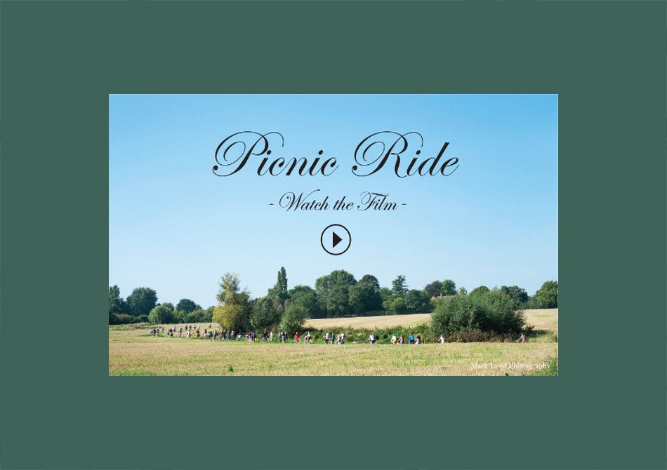 Screen shot of the Pashley picnic ride video showing riders cycling along a corn field near Stratford-upon-Avon.