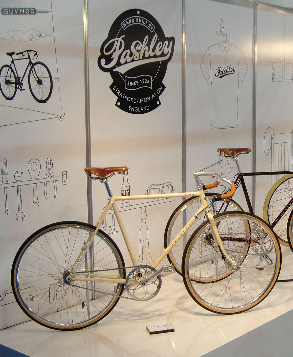 Pashley Clubman Prototype bicycle with leather bike saddle and grips, in front of a Pashley headbadge sign.