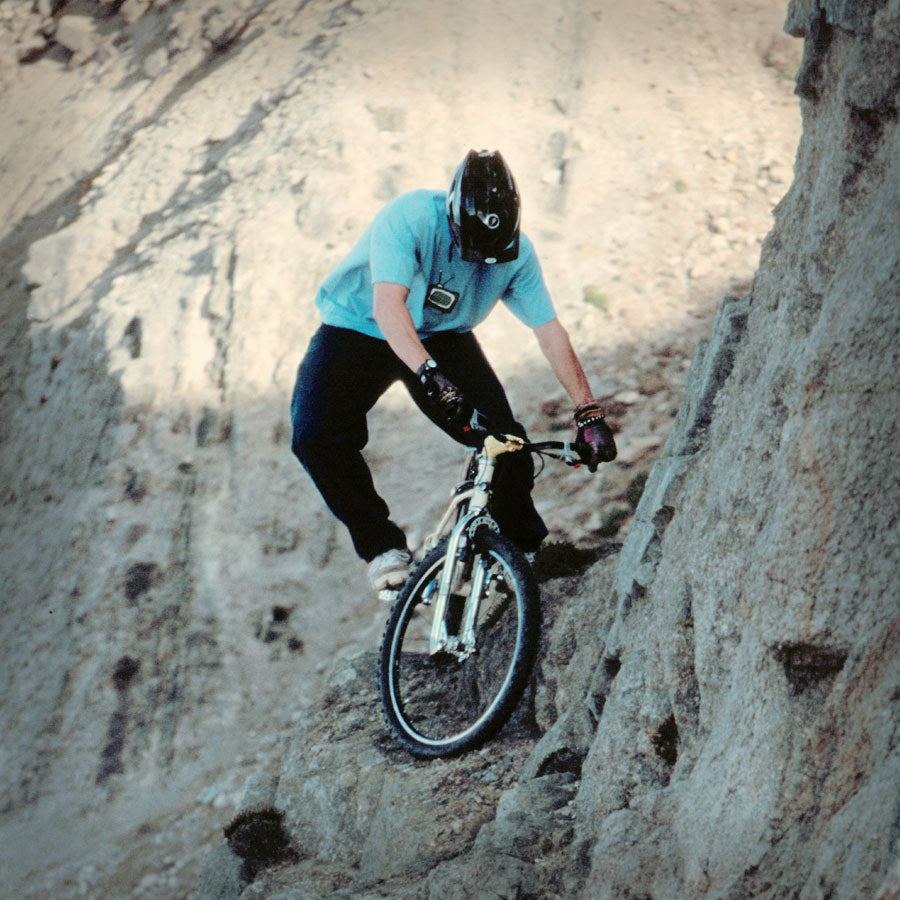 Eddie Tongue riding a Pashley 26Mhz trials bike on a rocky cliff face in a disused quarry.