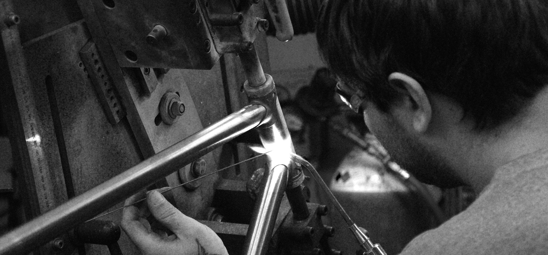 Close-up of a craftsman braising the front lug of a classic bike frame.