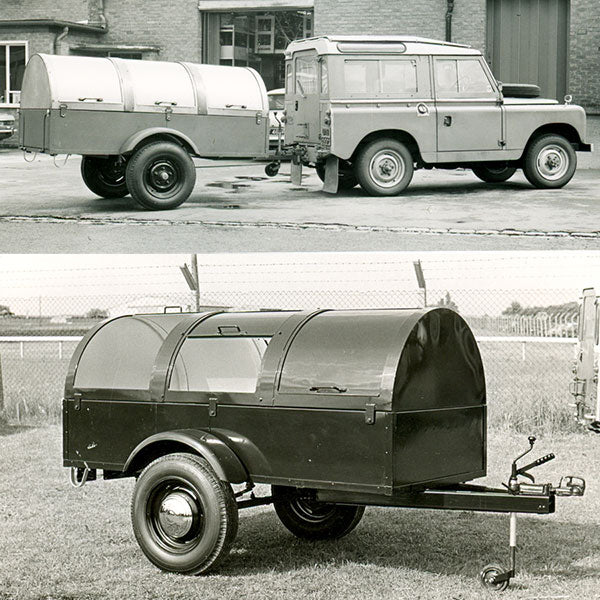 Vintage land rover car pulling a large covered trailer with arched roof