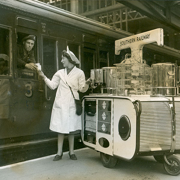 A lady on a station platform serving a soldier on a train from a Pashley hostess trolley 1940s host