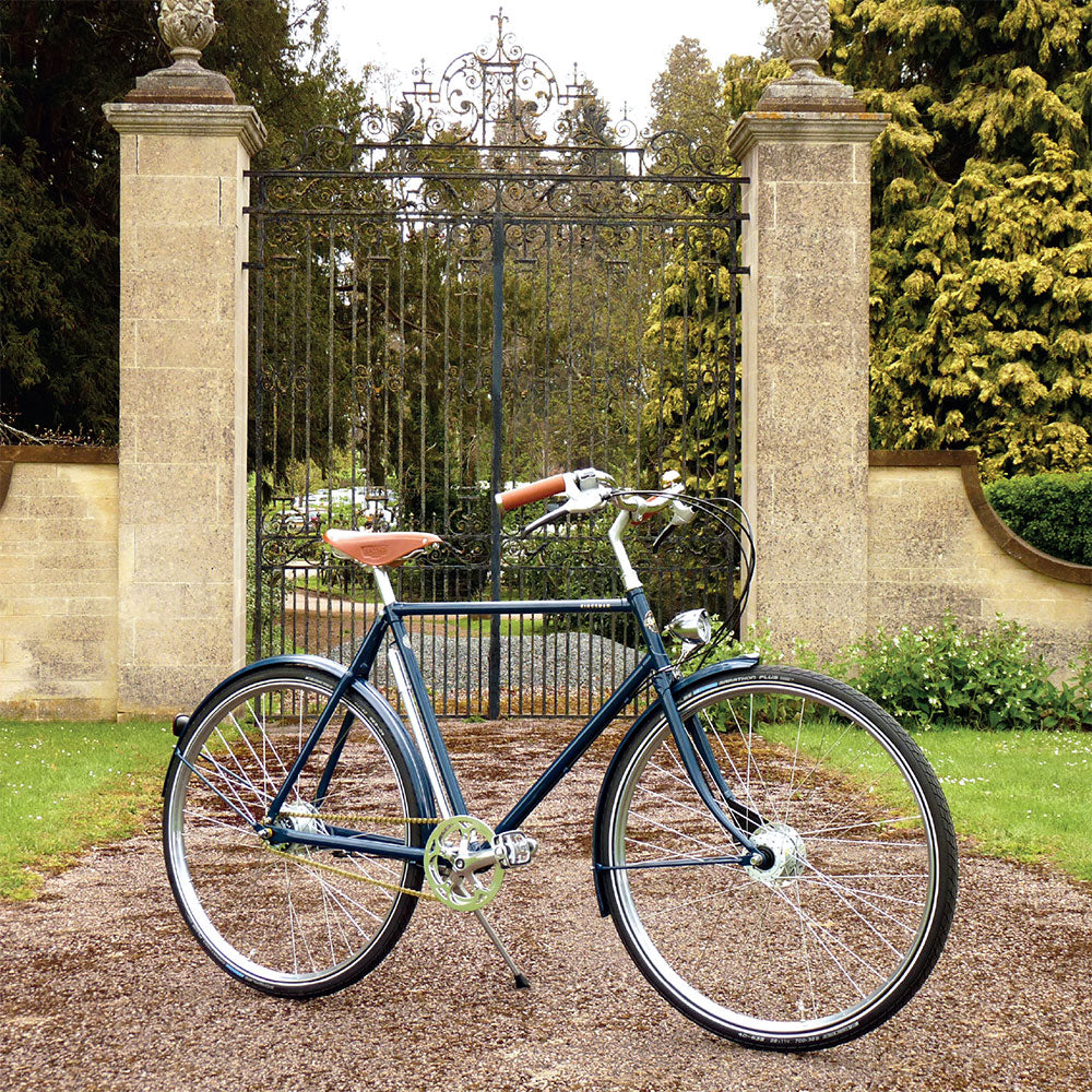 The Pashley Kingsman bicycle on a path in front of stately iron gates with stone pillars.