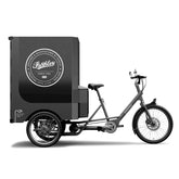Side view of electric cargo trike with large branded cargo box on the rear.